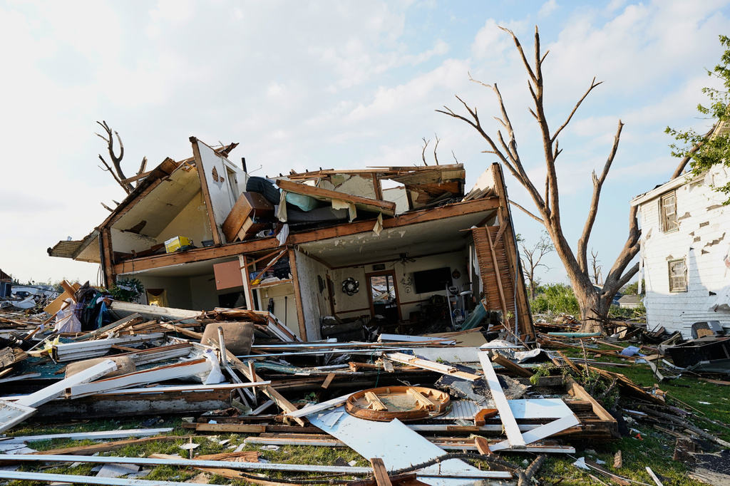 Debris is seen in front of a damaged house after a tornado struck Monday, July 27, 2026, in Menasha, Wis. (AP Photo/Kayla Wolf)
