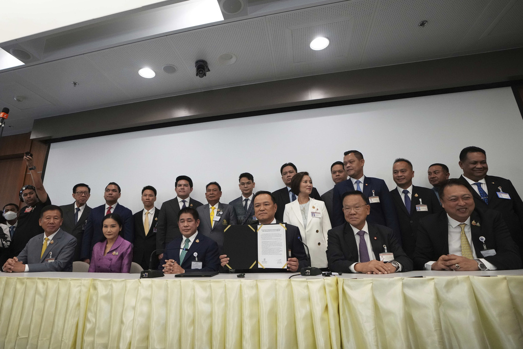 Leader of Bhumjai Thai Party Anutin Charnvirakul, fourth left in front, shows the signed Memorandum of Understanding between his coalition parties and the People's party at Parliament in Bangkok, Thailand, Wednesday, Sept. 3, 2025. (AP Photo/Sakchai Lalit)