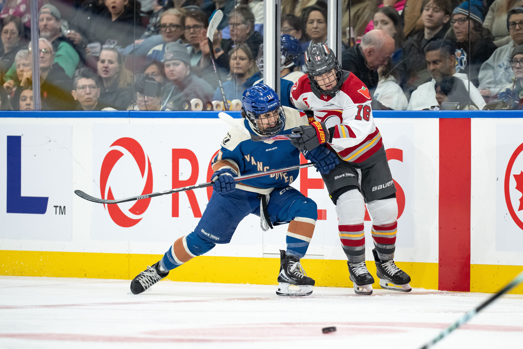 Vancouver Goldeneyes' Sydney Bard (11) and Ottawa Charge's Katerina Mrazova (16) vie for the puck during the third period of a PWHL hockey game in Vancouver, British Columbia, Saturday, March 14, 2026. (Ethan Cairns/The Canadian Press via AP)