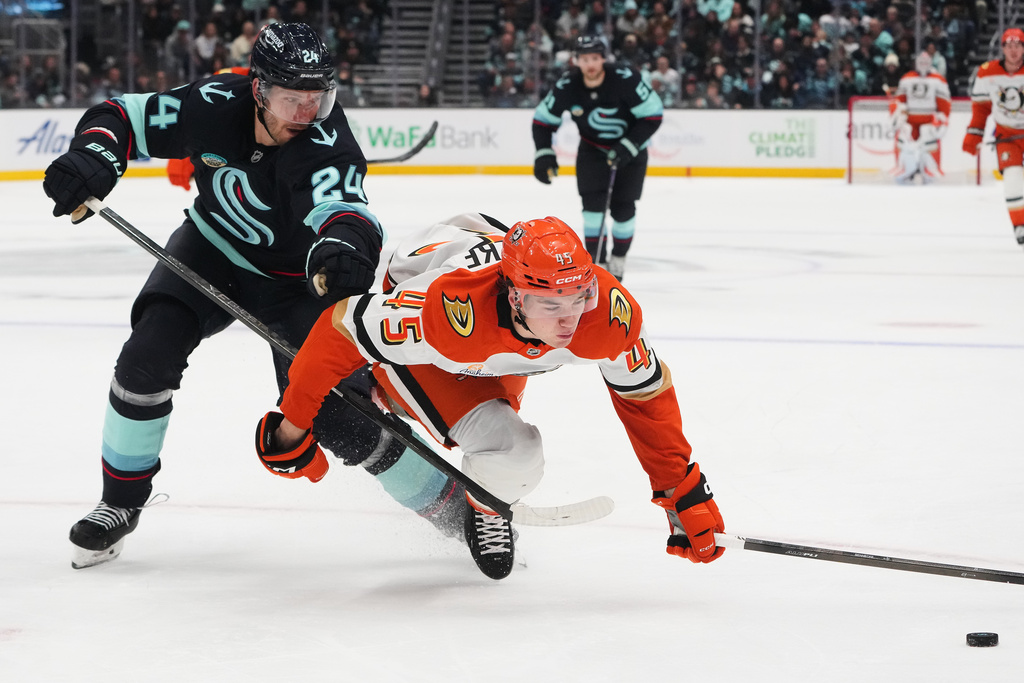 Seattle Kraken defenseman Jamie Oleksiak (24) looks on as Anaheim Ducks right wing Beckett Sennecke (45) falls while they vie for the puck during the second period of an NHL hockey game Thursday, Oct. 9, 2025, in Seattle. (AP Photo/Lindsey Wasson)