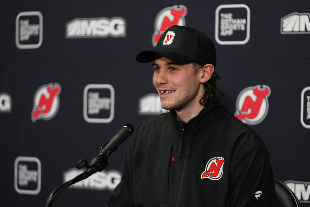 New Jersey Devils' Jack Hughes smiles while responding to questions during a news conference after an NHL hockey game against the Buffalo Sabres Wednesday, Feb. 25, 2026, in Newark, N.J. (AP Photo/Frank Franklin II)