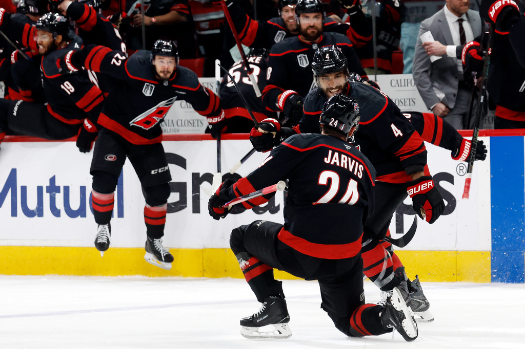 Carolina Hurricanes' Seth Jarvis (24) celebrates after his winning goal with Shayne Gostisbehere (4) during the overtime period in Game 2 of the NHL hockey Stanley Cup Final series against the Vegas Golden Knights in Raleigh, N.C., Thursday, June 4, 2026. (AP Photo/Karl DeBlaker)