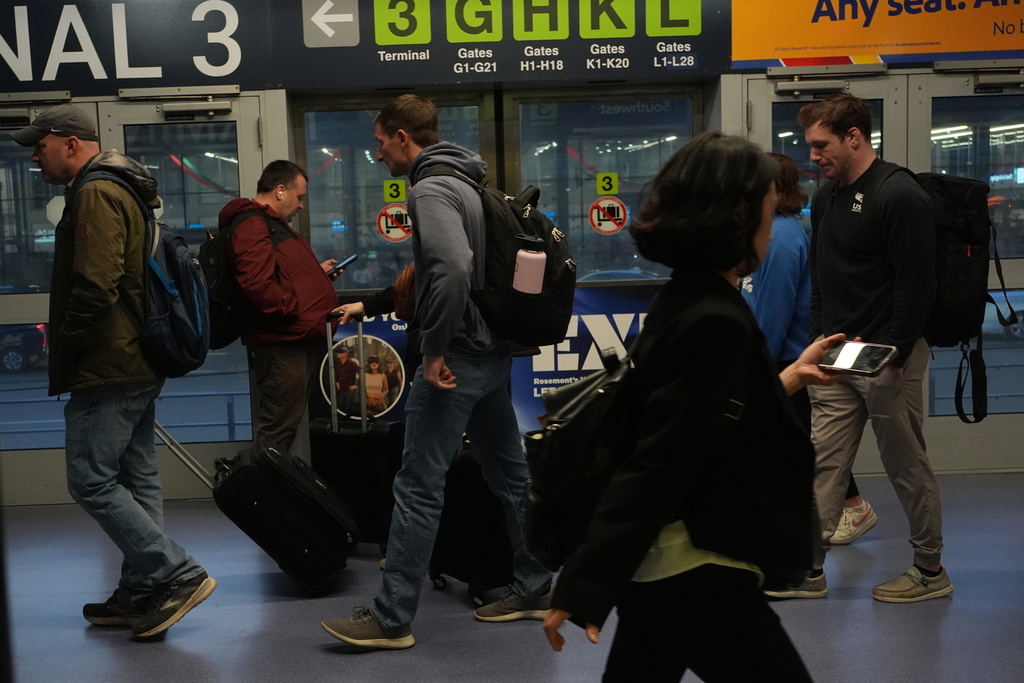 Travelers walk through the terminal at O'Hare International Airport in Chicago, Friday, Nov. 7, 2025. (AP Photo/Nam Y. Huh)