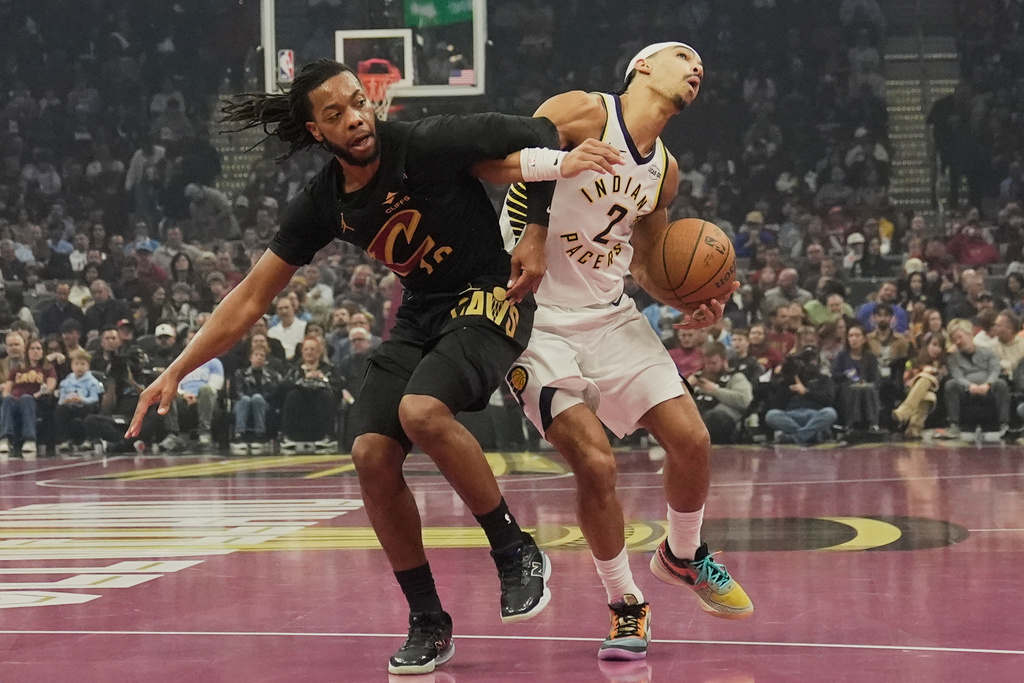 Cleveland Cavaliers guard Darius Garland, left, and Indiana Pacers guard Andrew Nembhard (2) get tangled up in the first half of an NBA Cup basketball game Friday, Nov. 21, 2025, in Cleveland. (AP Photo/Sue Ogrocki)