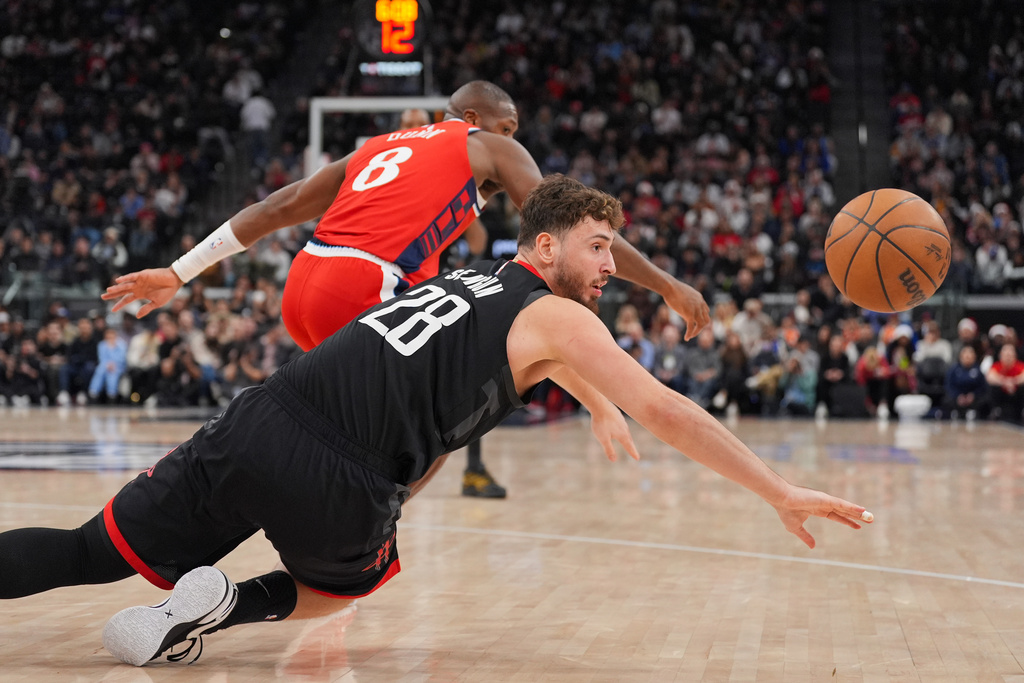 Houston Rockets center Alperen Sengun (28) reaches for a loose ball as Los Angeles Clippers guard Kris Dunn (8) watches during the first half of an NBA basketball game Tuesday, Dec. 23, 2025, in Inglewood, Calif. (AP Photo/Jae C. Hong)