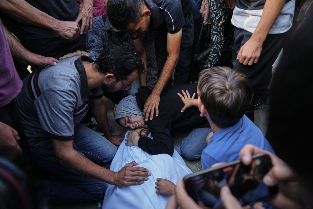Nahrawan Al-Khatib bids farewell to her husband, Yahya Barzaq, who was killed in an Israeli strike on Deir al-Balah, Gaza Strip, Wednesday, Oct. 1, 2025. (AP Photo/Abdel Kareem Hana)