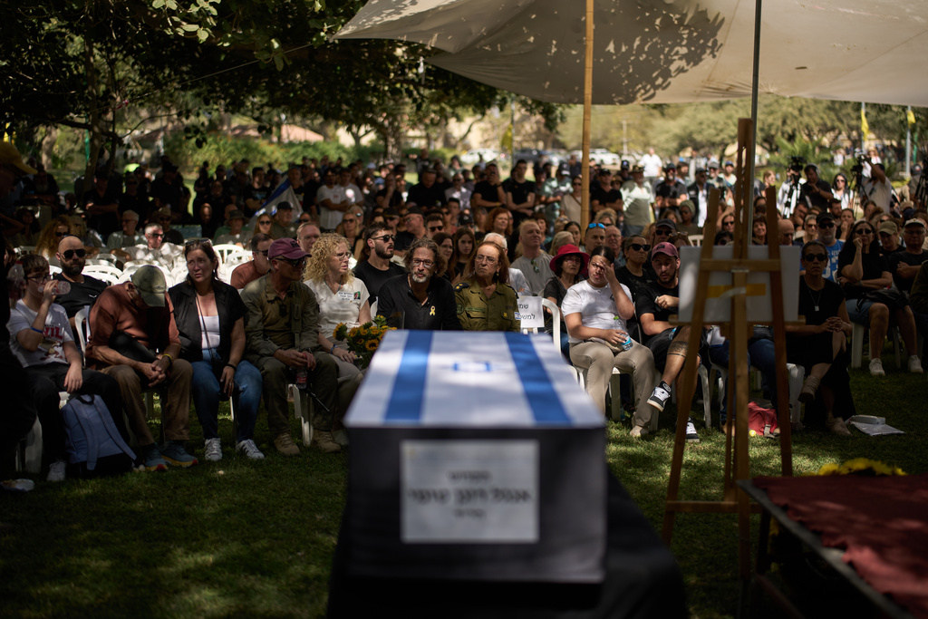 Relatives and friends attend the funeral of slain hostage Ronen Engel after his body was returned from Gaza as part of a ceasefire agreement between Israel and Hamas at Kibbutz Nir Oz, southern Israel, Tuesday, Oct. 21, 2025. (AP Photo/Leo Correa)