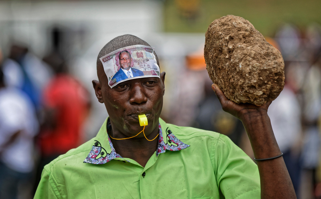 A supporter of opposition leader Raila Odinga wears a mock banknote with Odinga's face on his forehead at a rally in Uhuru Park in downtown Nairobi, Kenya Wednesday, Oct. 25, 2017. (AP Photo/Ben Curtis)
