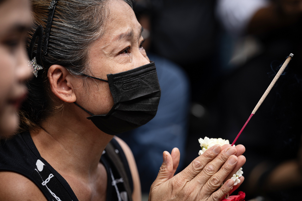 A woman weeps as she prays outside the music bar where a fire killed a number of people in Bangkok, Thailand, Tuesday, July 14, 2026. (AP Photo/Wason Wanichakorn)
