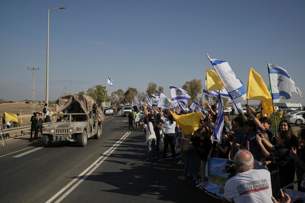 People react as a convoy carrying the hostages released from the Gaza Strip arrives at a military base near Reim, southern Israel, on Monday, Oct. 13, 2025. (AP Photo/Leo Correa)