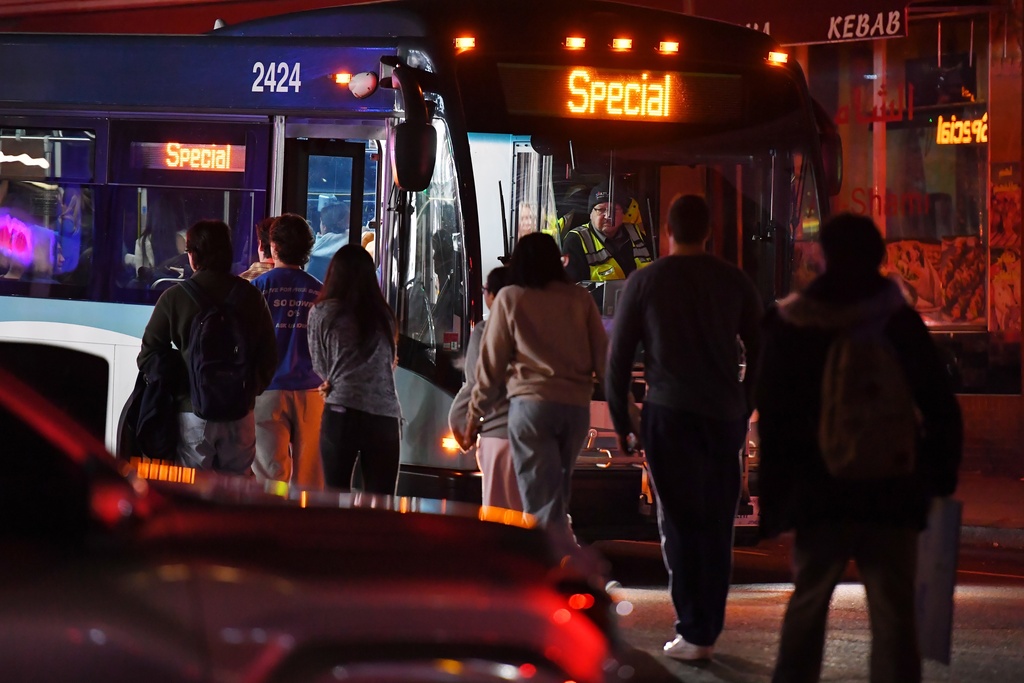 People board a bus in a neighborhood near Brown University, Saturday, Dec. 13, 2025, in Providence, R.I., during the investigation of a shooting. (AP Photo/Steven Senne)