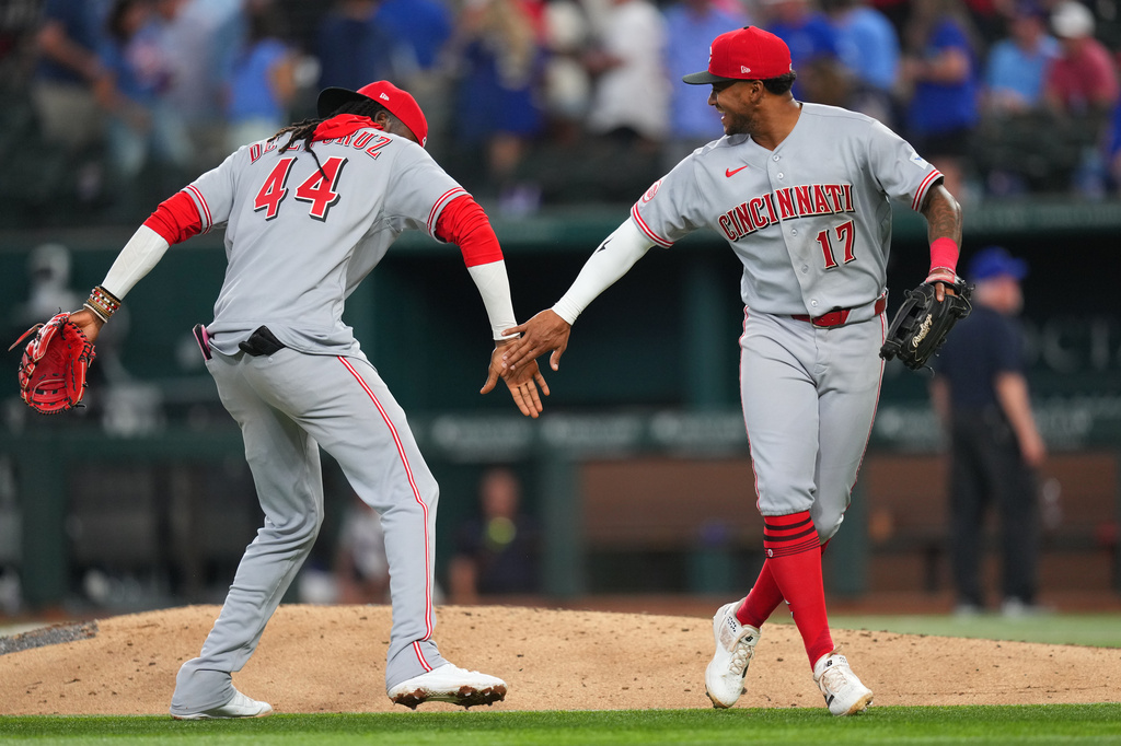 Cincinnati Reds shortstop Elly de la Cruz (44) and center fielder Dane Myers (17) react after their team defeated the Texas Rangers 5-3 during the Rangers' home-opener baseball game Friday, April 3, 2026, in Arlington, Texas. (AP Photo/Julio Cortez)