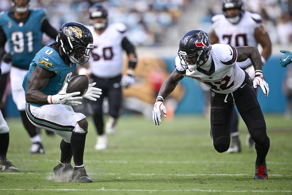 Jacksonville Jaguars linebacker Devin Lloyd, left, collects a fumble by Houston Texans wide receiver Nico Collins, right, during the second half of an NFL football game Sunday, Sept. 21, 2025, in Jacksonville, Fla. (AP Photo/Phelan M. Ebenhack)