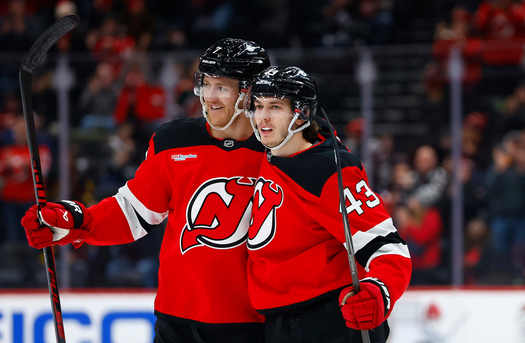 New Jersey Devils defenseman Luke Hughes (43) celebrates with Dougie Hamilton, left, after scoring against the Vancouver Canucks during the second period of an NHL hockey game, Sunday, Dec 14, 2025, in Newark, N.J. (AP Photo/Noah K. Murray)