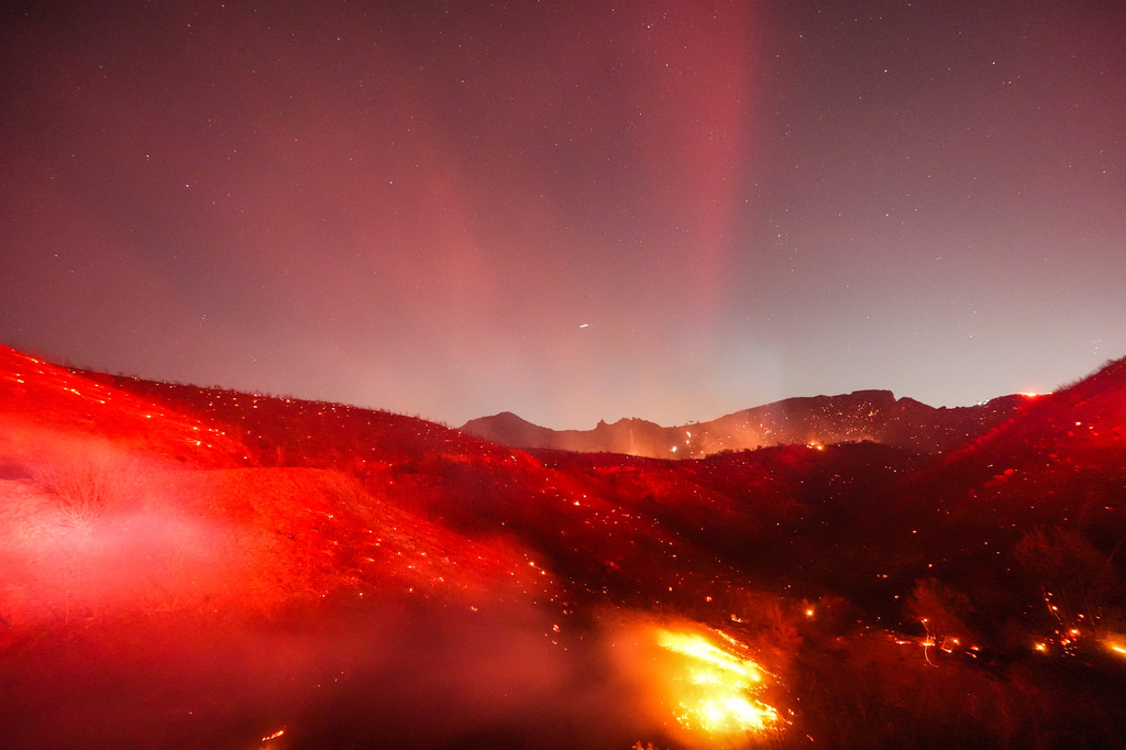 Hot spots glow across a hillside during the Bryson Fire in Malibu, Calif., Thursday, Oct. 15, 2026. (AP Photo/Jae C. Hong)