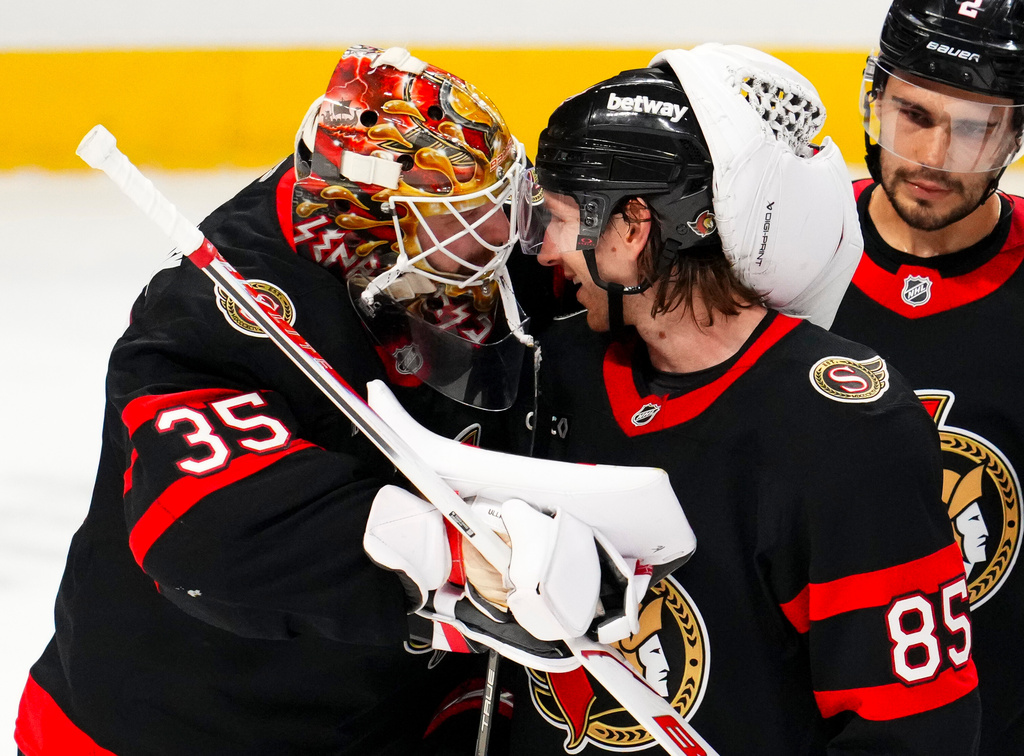 Ottawa Senators goaltender Linus Ullmark (35) and teammate Jake Sanderson (85) celebrating after defeating the Tampa Bay Lightning in an NHL hockey game in Ottawa, Ontario, Tuesday, April 7, 2026. (Sean Kilpatrick/The Canadian Press via AP)