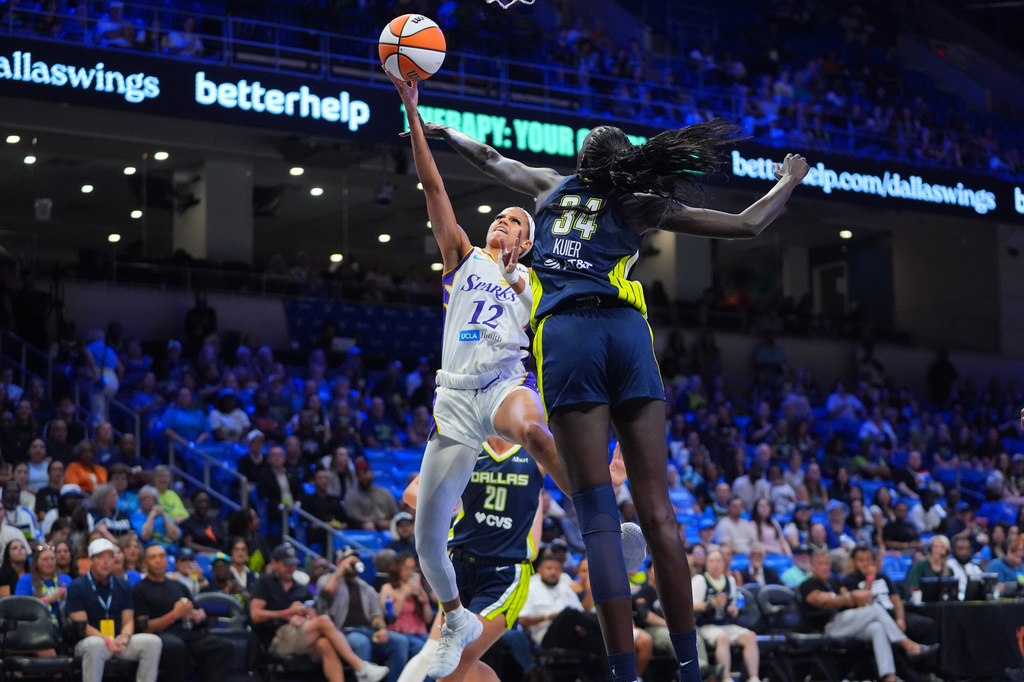 Los Angeles Sparks guard-forward Rae Burrell (12) shoots against Dallas Wings forward Awak Kuier (34) during the first half of a WNBA basketball game in Arlington, Texas, Thursday, Sept. 17, 2026. (AP Photo/LM Otero)
