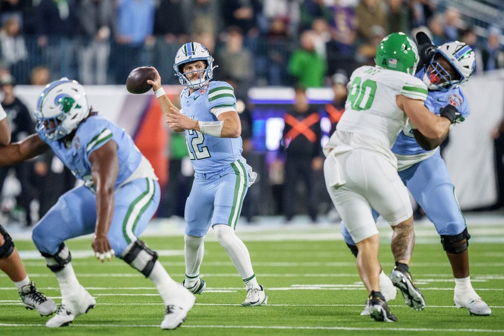 Tulane quarterback Jake Retzlaff (12) looks to throw against North Texas during the first half of the American Conference championship NCAA college football game in New Orleans, Friday, Dec. 5, 2025. (AP Photo/Matthew Hinton)