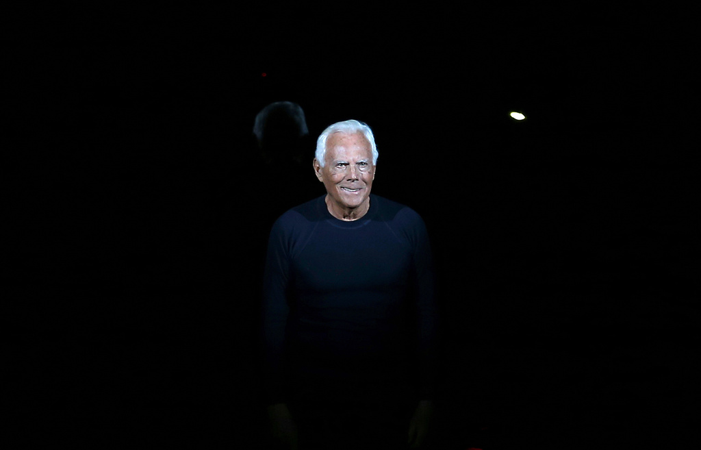 FILE - Italian fashion designer Giorgio Armani acknowledges applause at the end of his Emporio Armani men's Fall-Winter 2014 collection, part of the Milan Fashion Week, unveiled in Milan, Italy, Jan. 13, 2014. (AP Photo/Antonio Calanni, file)