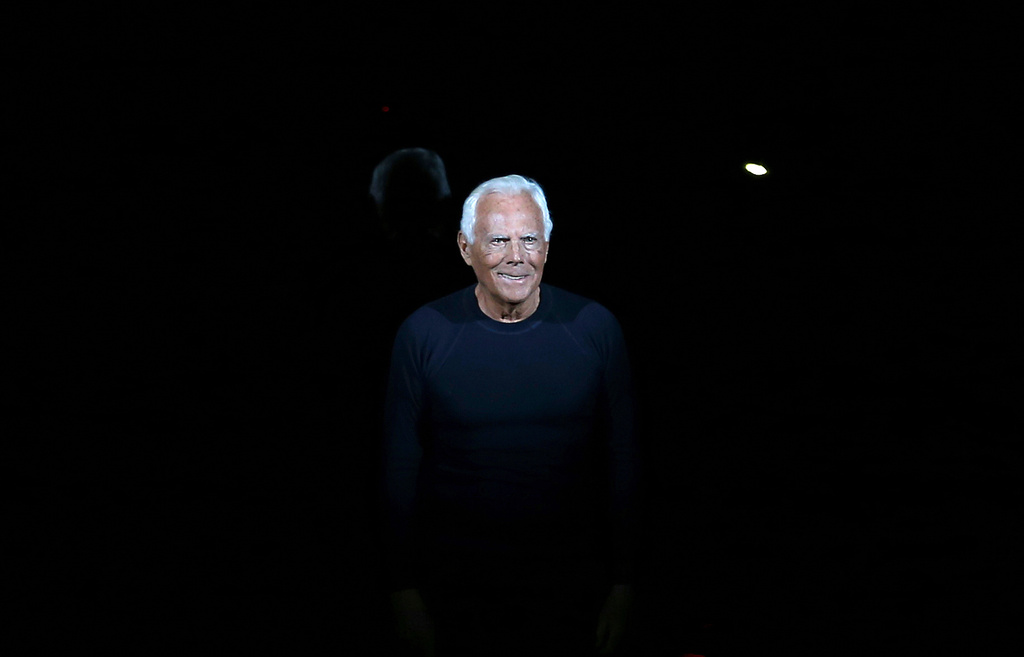 FILE - Italian fashion designer Giorgio Armani acknowledges applause at the end of his Emporio Armani men's Fall-Winter 2014 collection, part of the Milan Fashion Week, unveiled in Milan, Italy, Jan. 13, 2014. (AP Photo/Antonio Calanni, file)
