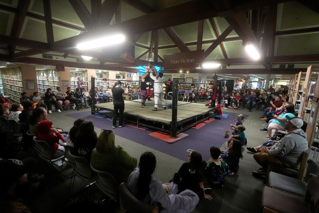 Fans watch a tag team match between Llama Jack and Astro Knox against Young Steel during a Lucha Libro pro wrestling event at Benicia Public Library Saturday, May 2, 2026, in Benicia, Calif. (AP Photo/Jeff Chiu)
