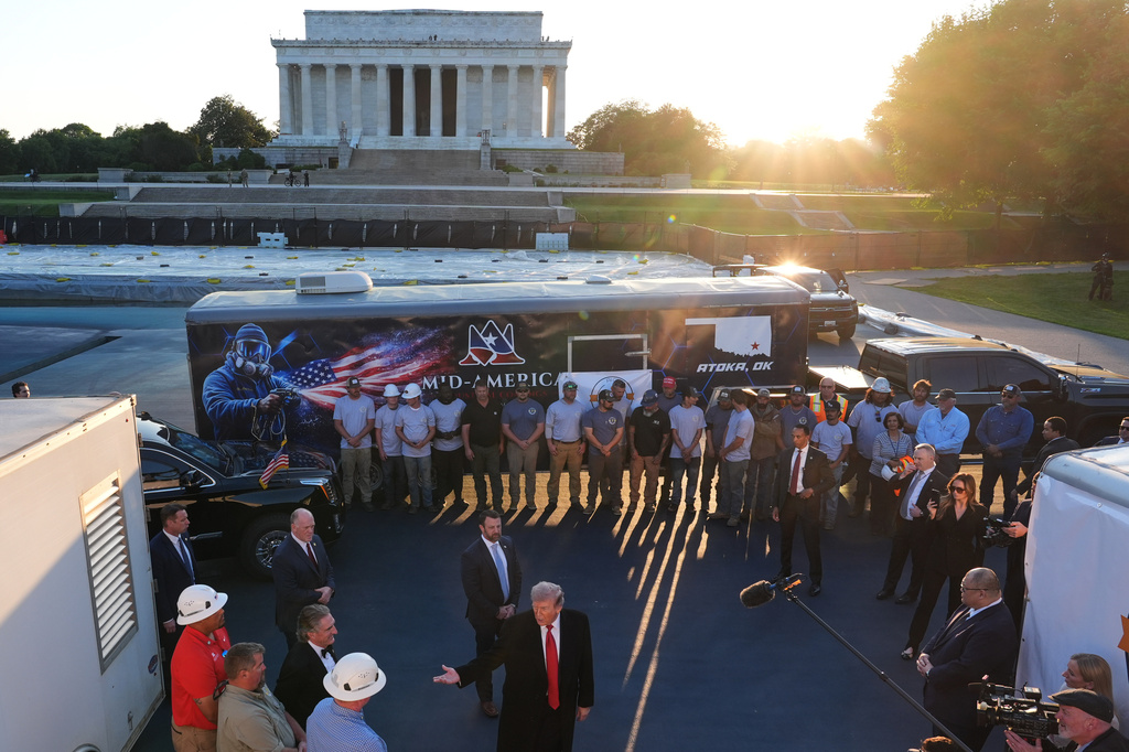 President Donald Trump talks as he visits the Lincoln Memorial Reflecting Pool to see the new blue protective coating being applied as part of a renovation project, Thursday, May 7, 2026, in Washington. (AP Photo/Mark Schiefelbein)