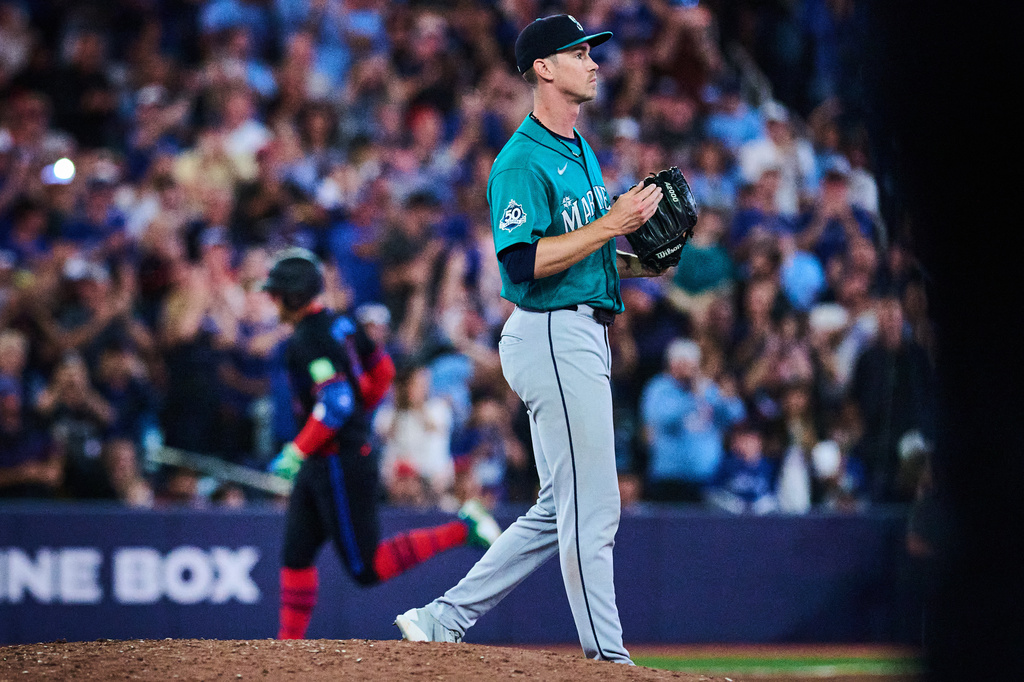 Seattle Mariners pitcher Emerson Hancock, right, reacts as Toronto Blue Jays' George Springer, back left, rounds the bases after hitting a solo home run during the fifth inning of a baseball game in Toronto, Friday, Aug. 28, 2026. (Sammy Kogan/The Canadian Press via AP)