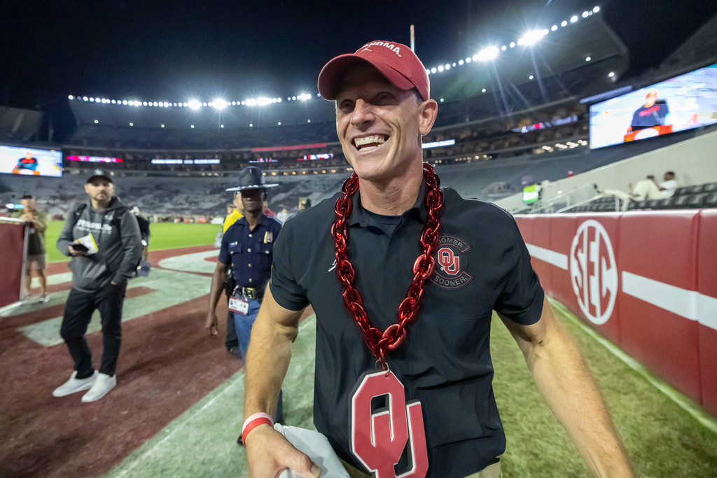 Oklahoma head coach Brent Venables wears an Oklahoma chain given to him postgame by a fan as he walks into the locker room after defeating Alabama at an NCAA college football game, Saturday, Nov. 15, 2025, in Tuscaloosa, Ala. (AP Photo/Vasha Hunt)