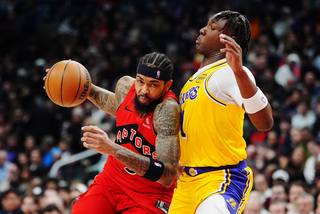 Toronto Raptors' Brandon Ingram (3) drives at Los Angeles Lakers' Adou Thiero (1) during first half NBA basketball action in Toronto on Thursday, Dec. 4, 2025. (Frank Gunn/The Canadian Press via AP)