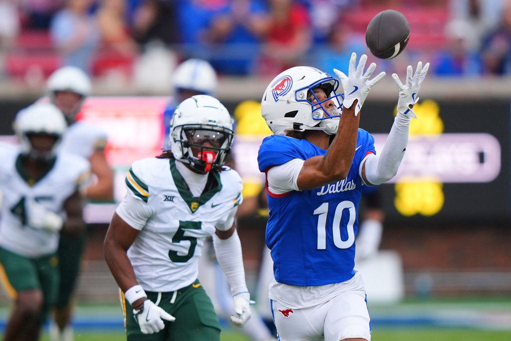 SMU wide receiver Jalen Cooper (10) catches a touchdown pass in front of Baylor defender Carl Williams (5) during the first half of an NCAA college football game Saturday, Sept. 6, 2025, in Dallas. (AP Photo/LM Otero)
