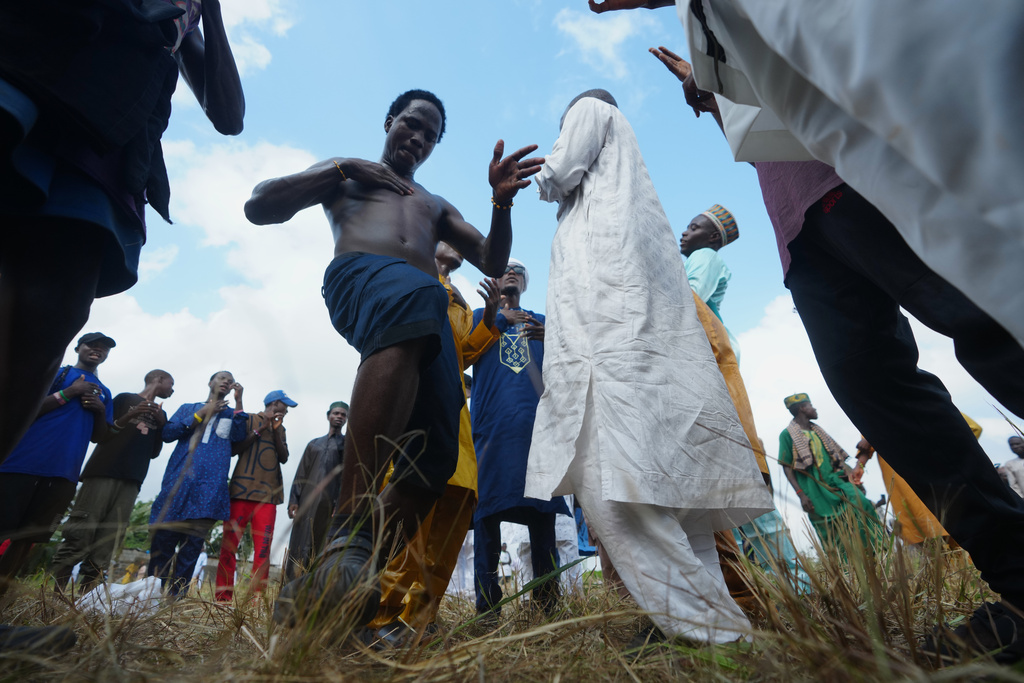Young men sing and dance after Eid al-Fitr prayers, marking the end of the fasting month of Ramadan in Lagos, Nigeria, Friday, March 20, 2026. (AP Photo/Sunday Alamba)