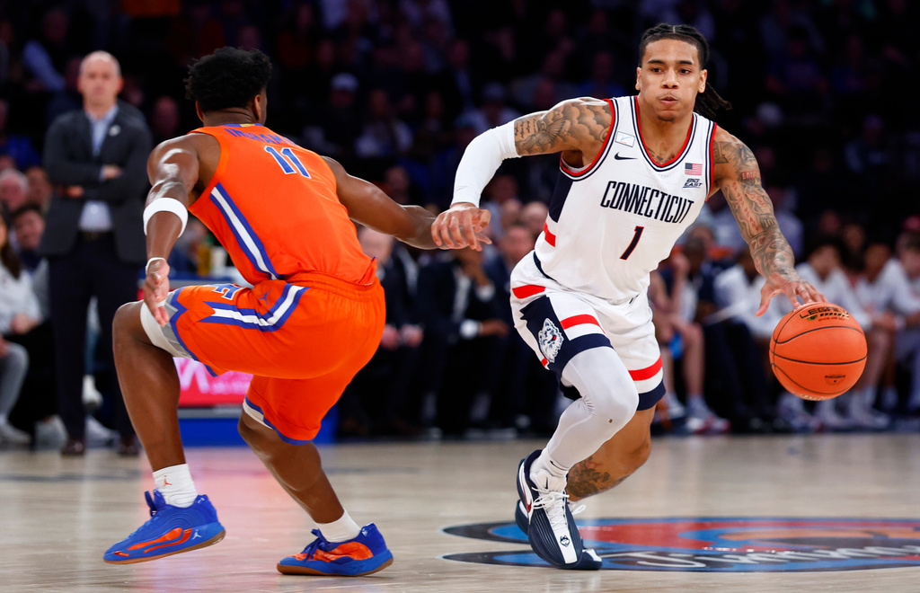 UConn guard Solo Ball (1) drives to the basket against Florida guard CJ Ingram II (11) during the first half of an NCAA basketball game, Tuesday, Dec. 9, 2025, in New York. (AP Photo/Noah K. Murray)