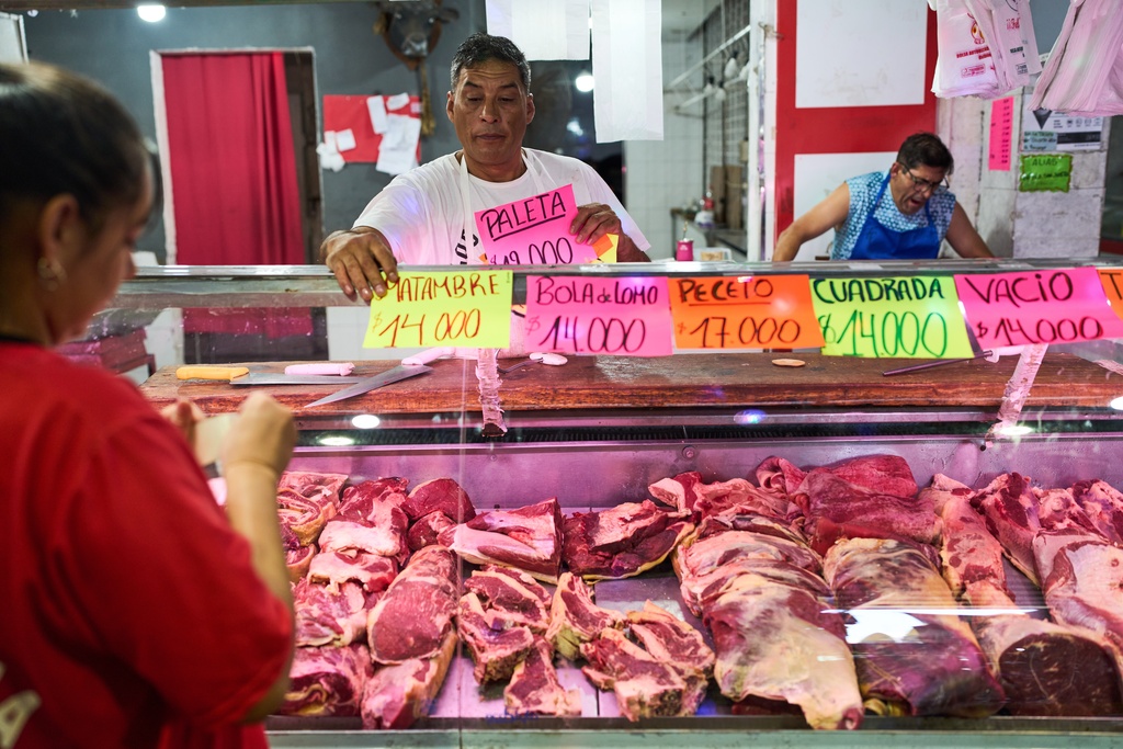 A butcher shop worker displays the prices of different cuts of meat in Buenos Aires, Argentina, Tuesday, Feb. 10, 2026. (AP Photo/Rodrigo Abd)