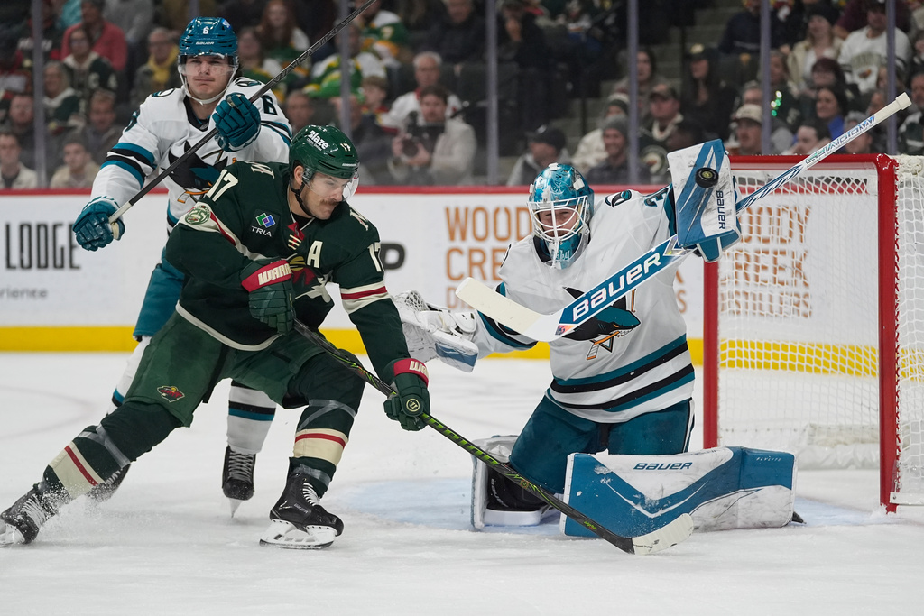 San Jose Sharks goaltender Yaroslav Askarov (30) stops a shot as Minnesota Wild left wing Marcus Foligno (17) pressures during the first period of an NHL hockey game, Tuesday, Nov. 11, 2025, in St. Paul, Minn. (AP Photo/Abbie Parr)