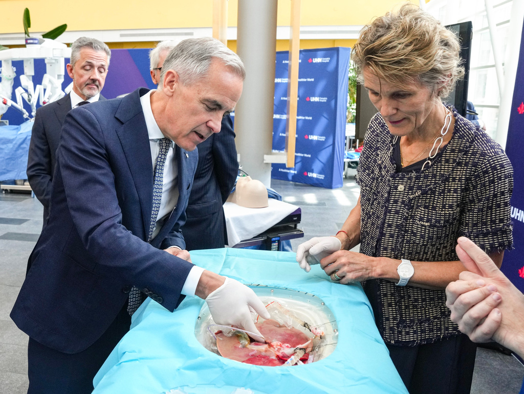Prime Minister Mark Carney and his wife Diana Fox Carney inspects a pig's lungs during an AI demonstration as they visit Toronto General Hospital on Thursday, June 4 2026. (Chris Young /The Canadian Press via AP)