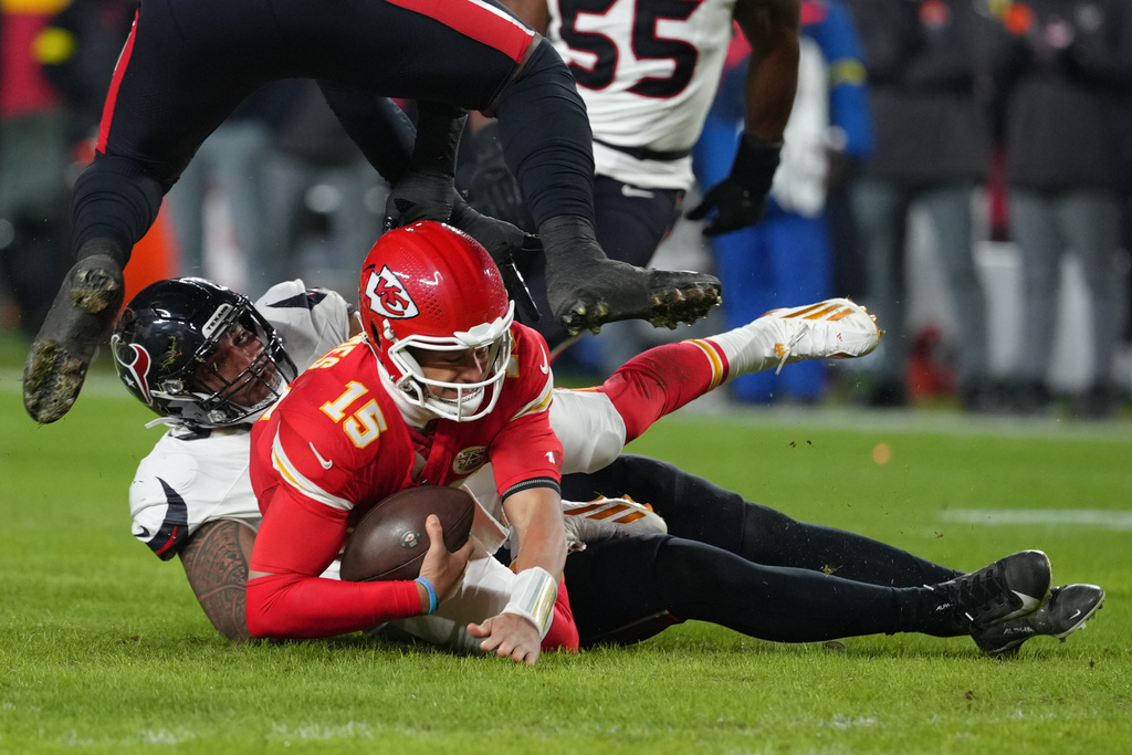 Kansas City Chiefs quarterback Patrick Mahomes (15) is sacked by Houston Texans defensive tackle Tommy Togiai during the first half of an NFL football game Sunday, Dec. 7, 2025, in Kansas City, Mo. (AP Photo/Ed Zurga)