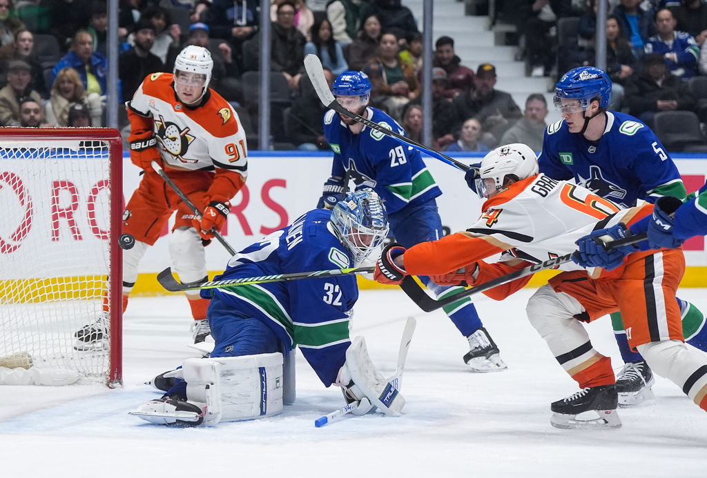 Anaheim Ducks' Mikael Granlund, front right, scores against Vancouver Canucks goalie Kevin Lankinen (32) as Tom Willander (5), Marcus Pettersson (29) and Anaheim's Leo Carlsson (91) watch during the second period of an NHL hockey game, in Vancouver, on Tuesday, March 24, 2026. (Darryl Dyck/The Canadian Press via AP)