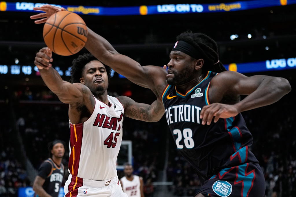 Miami Heat guard Davion Mitchell, left, and Detroit Pistons guard Cade Cunningham vie for the ball during the first half of an NBA basketball game, Thursday, Jan. 1, 2026, in Detroit. (AP Photo/Ryan Sun)
