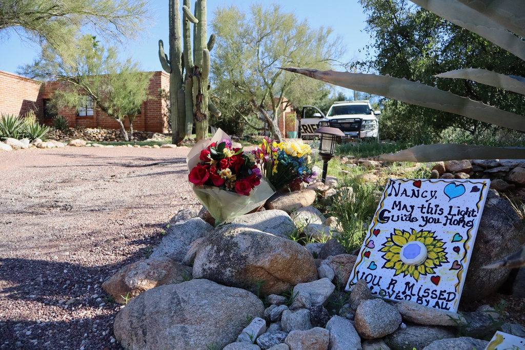 A memorial grows outside the home of Nancy Guthrie, the missing mother of "Today" show host Savannah Guthrie, in Tucson, Ariz., Sunday, Feb. 22, 2026. (AP Photo/Felicia Fonseca)