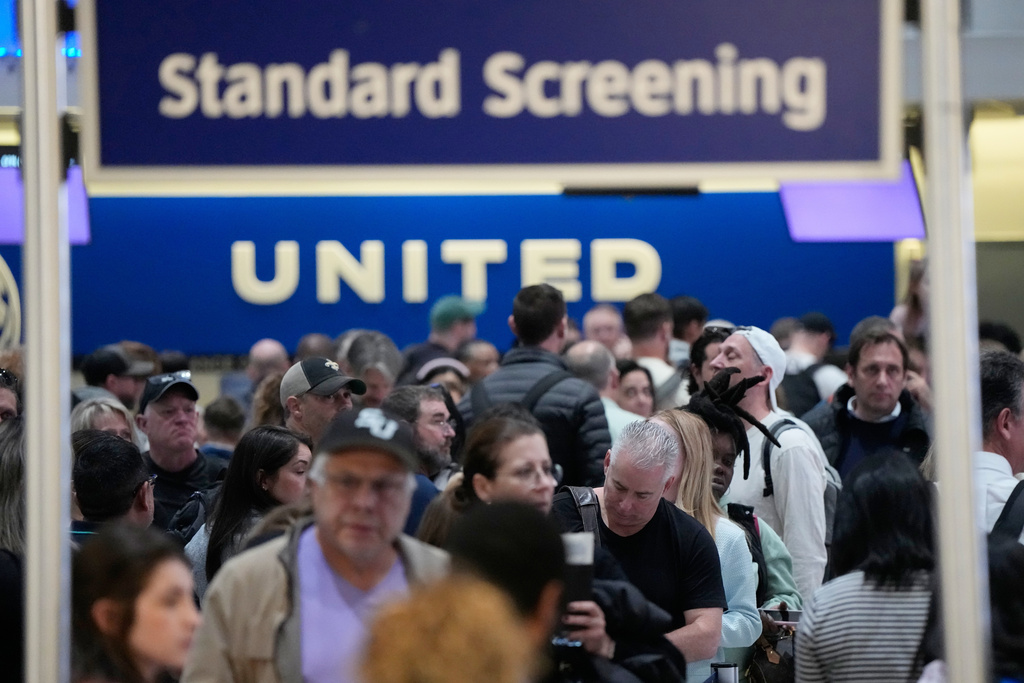Passengers wait in a long security checkpoint line at George Bush Intercontinental Airport Thursday, March 19, 2026, in Houston. (AP Photo/David J. Phillip)