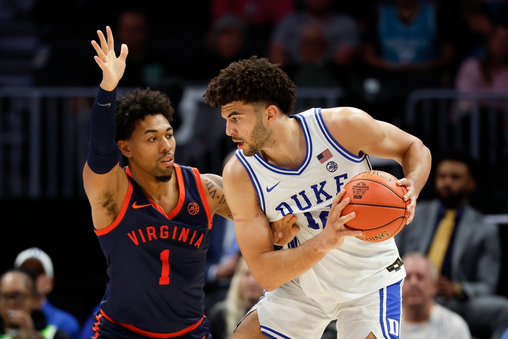 Duke forward Cameron Boozer, right, looks to drive against Virginia guard Malik Thomas (1) during the second half of an NCAA college basketball game in the championship of the Atlantic Coast Conference tournament in Charlotte, N.C., Saturday, March 14, 2026. (AP Photo/Nell Redmond)
