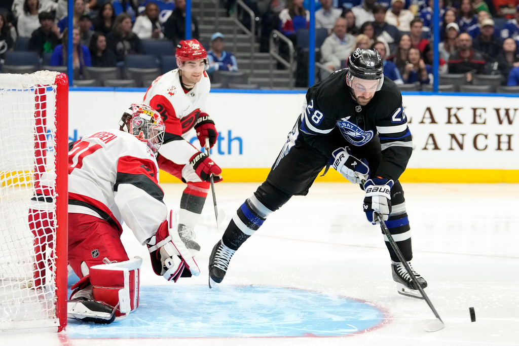 Tampa Bay Lightning center Zemgus Girgensons (28) loses control of the puck in front of Carolina Hurricanes goaltender Frederik Andersen (31) during the second period of an NHL hockey game Saturday, March 14, 2026, in Tampa, Fla. (AP Photo/Chris O'Meara)