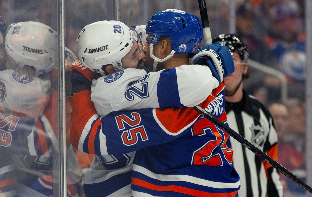 Tampa Bay Lightning's Nick Paul (20) and Edmonton Oilers' Darnell Nurse (25) rough it up during first-period NHL hockey game action in Edmonton, Alberta, Saturday March 21, 2026. (Jason Franson/The Canadian Press via AP)