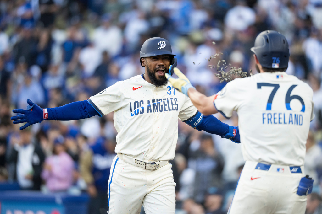 Los Angeles Dodgers' Teoscar Hernández, left, celebrates his three-run home run with Alex Freeland during the first inning of a baseball game against the Texas Rangers in Los Angeles, Saturday, April 11, 2026. (AP Photo/Kyusung Gong)