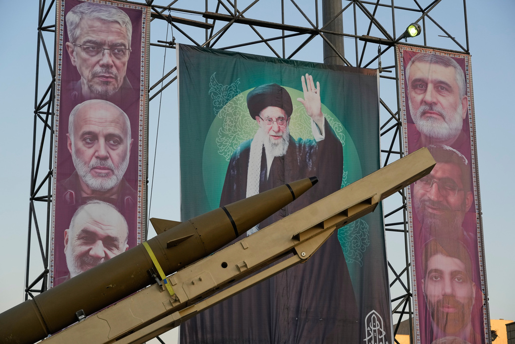 A domestically-built missile "Khaibar-buster," and banners showing portraits of the Iranian Supreme Leader Ayatollah Ali Khamenei, center, and the late armed forces commanders, who were killed in Israeli strike in June, are displayed in a military exhibition commemorating the anniversary of the start of the 1980-88 Iraq-Iran war, and 12-day war with Israel in June, at Baharestan Square, in Tehran, Thursday, Sept. 25, 2025. (AP Photo/Vahid Salemi)