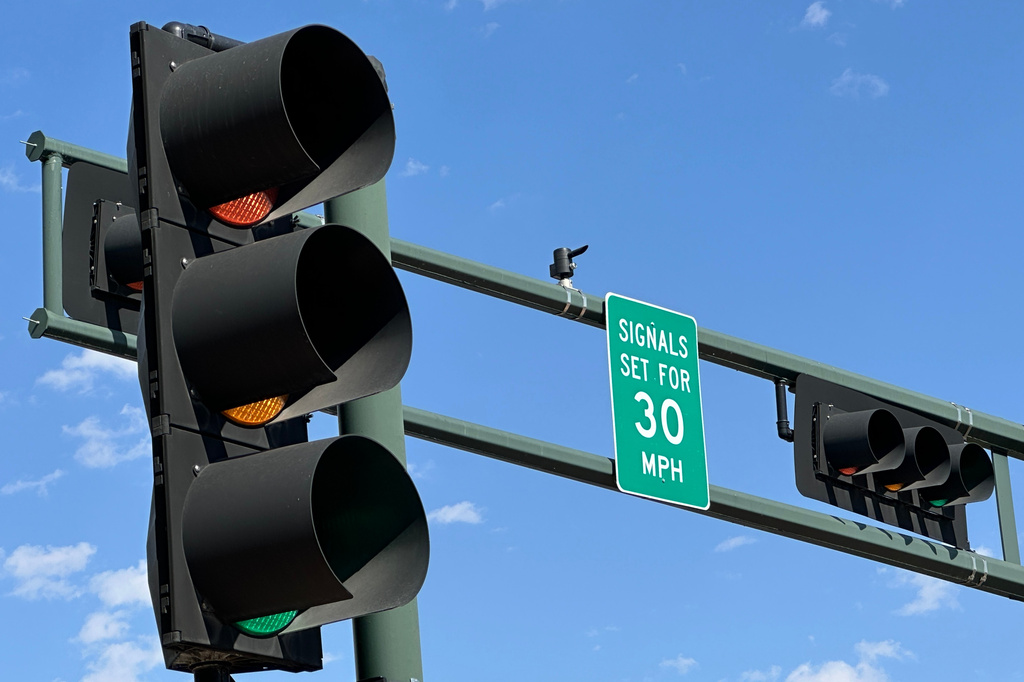 A sign notifies drivers that stoplights are set for a specific speed limit as part of the "rest on red" signal program in Albuquerque, N.M., Wednesday, Aug. 12, 2026. (AP Photo/Susan Montoya Bryan)