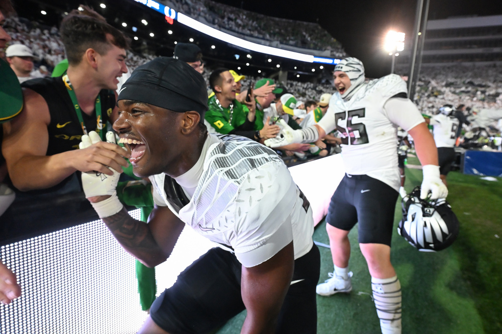 Oregon linebacker Nasir Wyatt (32) and Oregon offensive lineman Trent Ferguson (56) celebrate their second overtime win over Penn State during their NCAA college football game, Saturday, Sept. 27, 2025, in State College, Pa. (AP Photo/Barry Reeger)