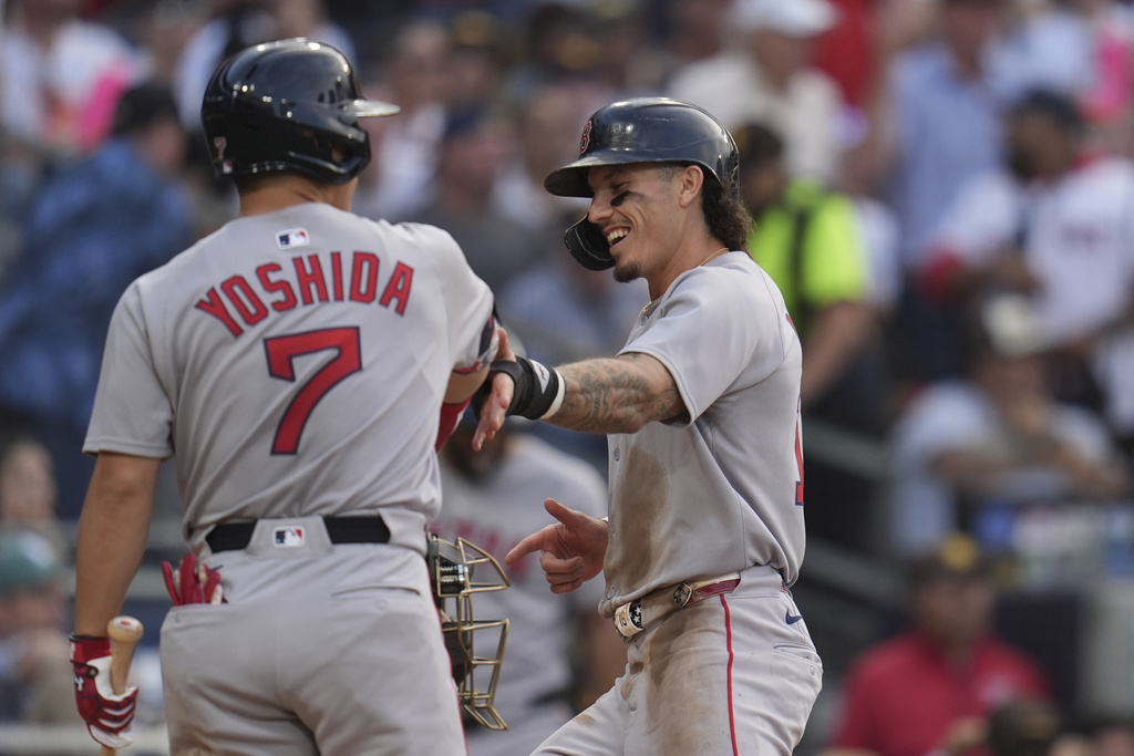 Boston Red Sox's Jarren Duran, right, celebrates with teammate Masataka Yoshida (7) after scoring from third base on a balk during the third inning of a baseball game against the San Diego Padres Saturday, Aug. 9, 2025, in San Diego. (AP Photo/Gregory Bull)