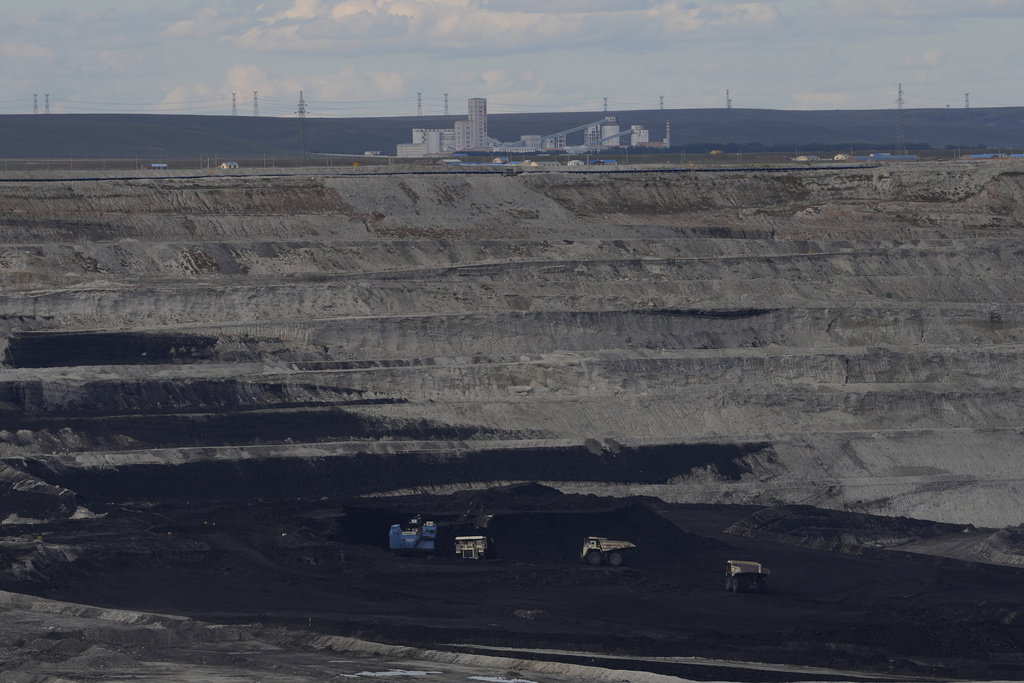 Traditional manned trucks operate in the Huaneng Yimin open-pit coal mine in Hulunbuir in northern China's Inner Mongolia province China, Monday, Sept. 15, 2025. (AP Photo/Ng Han Guan)