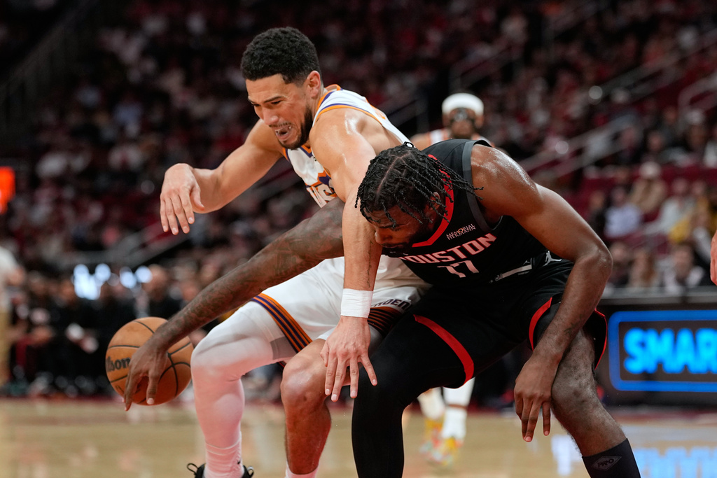 Houston Rockets' Tari Eason (17) knocks the ball away from Phoenix Suns' Devin Booker during the first half of an NBA basketball game Monday, Jan. 5, 2026, in Houston. (AP Photo/David J. Phillip)